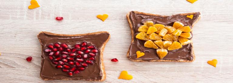 Chocolate toast topped with pomegranate and orange hearts.