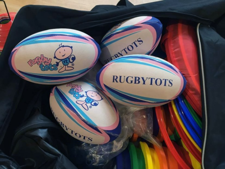 RugbyTots branded rugby balls with colorful equipment.