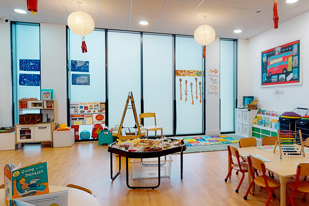 Bright classroom corner with play kitchen, art, and learning materials.