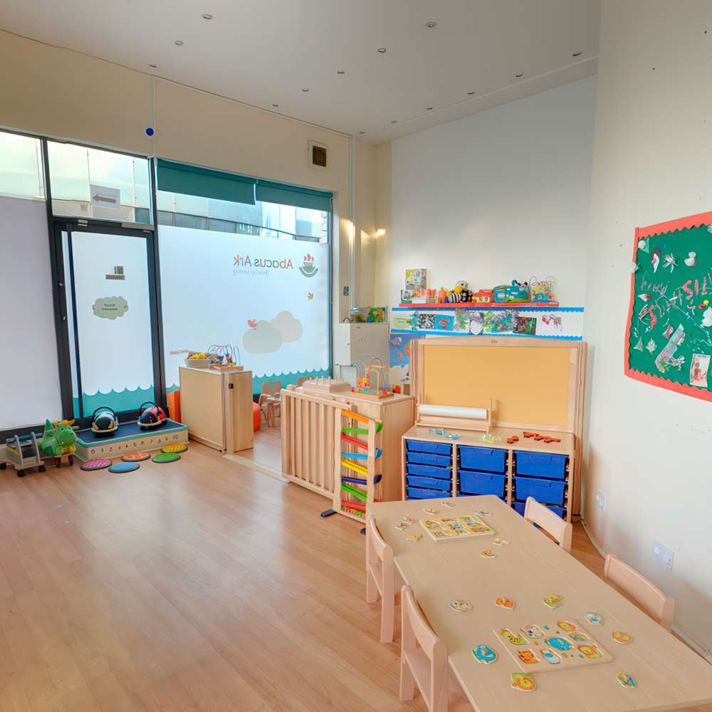 Bright classroom with toys, storage units, and activity tables.