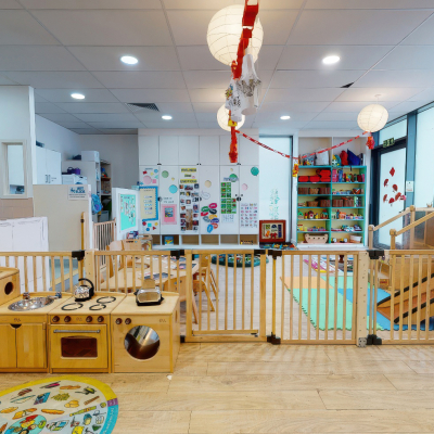 Nursery room with play kitchen, shelves, and learning displays.